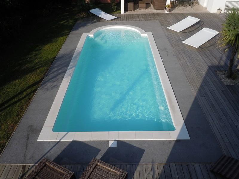 Piscine RÉ de 9 mètres 50 par 3 mètres 80 à fond plat avec un escalier roman. Piscine parfaite pour nager et jouer en famille.